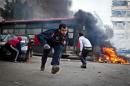Supporters of Egypt's deposed president Mohamed Morsi run for cover from tear gas fired by riot police during clashes in the northeastern part of Cairo's Nasr City district on January 3, 2014