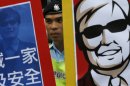 A police officer stands guard in the middle of two images featuring blind Chinese activist Chen Guangcheng during a protest in front of the Chinese central government's liaison in Hong Kong Friday, May 4, 2012. Chen at the center of a diplomatic standoff between the United States and China said Friday his situation is 