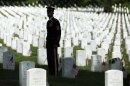 A member of the honor guard stands at attention as Obama arrives in his motorcade for Memorial Day observances at Arlington National Cemetery in Arlington