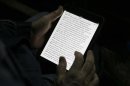 A man reads the bible from an iPad mini at the "Christ is the Answer International Ministries" group's camp near Florence