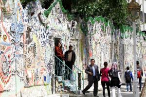 Syrians walk through a decorated wall that won the &hellip;