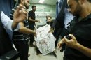 Palestinians wheel the body of a militant at a hospital, following an Israeli air strike in the northern Gaza Strip