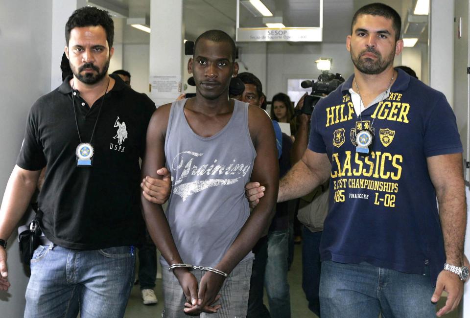 Sailson Jose das Gracas is escorted by policemen at a police station in Nova Iguacu near Rio de Janeiro