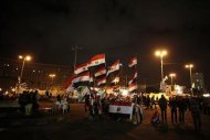 People walk past a stall displaying Egyptian flags for sale at Tahrir Square where protesters opposing President Mohamed Mursi are camping in Cairo December 19, 2012. REUTERS/Khaled Abdullah