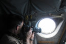 In this Jan. 25, 2013 photo, a detection officer with U.S. Customs and Border Protection takes photos of a potential drug-carrying boat from inside a P3 Orion Airborne Early Warning Aircraft while flying over waters near the Pacific coast of Costa Rica. The Central American country abolished its army in 1948 and plowed money into education, social benefits and environmental preservation. As a result, Costa Rican officials say, the country can't battle ruthless and well-equipped Mexican drug cartels without U.S. help. The U.S. is patrolling Costa Rica's skies and waters and providing millions of dollars in training and equipment to Costa Rican officials who have launched a tough line on crime backed by top-to-bottom transformation of the law-enforcement and justice systems. (AP Photo/Michael Weissenstein)