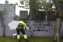 Un operario del cementerio de Zarautz borra pintadas de apoyo a la banda terrorista ETA aparecidas este viernes. EFE