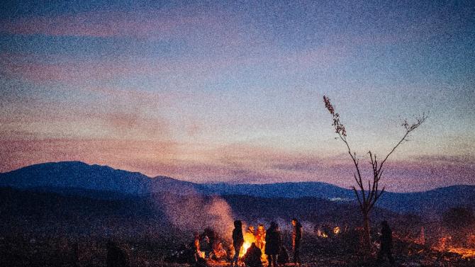 Migrants and refugees keep warm around a bonfire as they wait to enter a registration camp after crossing the Greek-Macedonian border near Gevgelija on November 15, 2015
