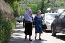 A Druze woman walks with a Christian woman in the village of Brih
