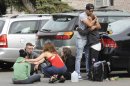 Hofstra University students gather near the house where another student and an armed intruder were killed during an overnight house break-in next to the campus, Friday, May 17, 2013, in Uniondale, N.Y. (AP Photo/ Louis Lanzano)