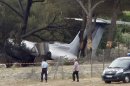 Police Officers walk near the plane that crashed on landing at Le Castellet airport, near Toulon, southern France, Friday, July 13, 2012. Three US citizen died in the accident. (AP Photo/Claude Paris)