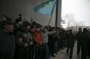 Crimean Tatars hold their flag during rallies near the Crimean parliament building in Simferopol
