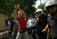 <p> A handcuffed protester, arrested during an anti-government demonstration on the outskirts of Athens where TV transmitters are located, flashes a V sign upon his arrival at the court in Greek capital on Tuesday, July 30, 2013. It was latest protest in the wake of a decision by Greece's conservative-led government to shut down state broadcaster ERT in June, to open a new public TV and radio station with fewer staff later this year. (AP Photo/Angeliki Panagiotou, FOSPHOTOS)