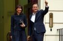 Britain's PM Cameron gives a thumb up as he arrives with his wife Samantha at the Conservative Party headquarters in London