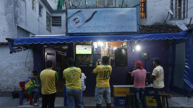 Brazilian fans watch the soccer game against Cameroon during the 2014 soccer World Cup at the Cantagalo favela in Rio de Janeiro, Brazil, Monday, June 23, 2014. Brazil&#39;s Neymar scored twice in the first half to lead Brazil to a 4-1 win over Cameroon on Monday, helping the hosts secure a spot in the second round of the World Cup. (AP Photo/Silvia Izquierdo)