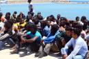 Illegal migrants sit after they are rescued by the Libyan coastguard in Tripoli, Libya on July 17, 2014