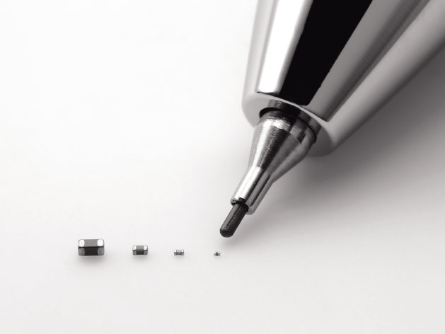 In this undated photo released by Murata Manufacturing Co., its latest capacitor, measuring just 0.25 millimeter by 0.125 millimeter, right, is pointed by a mechanical pencil as it is displayed with its bigger size models. Small is big for Murata: The Japanese electronics maker has developed the world's tiniest component known as the capacitor. And that's big business. Capacitors, which store electric energy, are used in the dozens, even in the hundreds, in just about every type of gadget - smartphones, laptops, hybrid cars, medical equipment and digital cameras. (AP Photo/Murata Manufacturing Co.) NO SALES