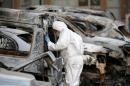 A French police officer inspects burned vehicles outside the Splendid Hotel in Ouagadougou