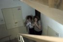 FILE - In this Nov. 19, 2012 file photo, Israeli women take cover in a stairwell as a siren signals the warning of incoming rockets in the coastal city of Ashkelon. (AP Photo/Tsafrir Abayov, File)