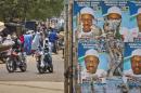 Traffic passes by campaign posters for opposition candidate Gen. Muhammadu Buhari plastered on the centre of a roundabout in Daura, his home town, in Katsina state in northern Nigeria Friday, March 27, 2015. The imam of the Emir's Palace Mosque in Daura called during traditional Friday prayers for worshippers to pray for free and fair elections, which are due to be held on Saturday. (AP Photo/Ben Curtis)