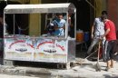 Youths clean up shattered glass near the site of a bomb attack in Dora district in Baghdad