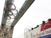 Passengers on a tour bus look up at the Olympic rings attached to the walkways over Tower Bridge in central London