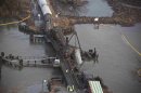 Derailed freight train cars sit semi-submerged in the waters of Mantua Creek after a train crash in Paulsboro