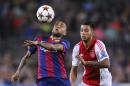 Barcelona's Dani Alves, left controls the ball in front of Ajax's Ricardo Kishna during the Champions League group F soccer match between F.C. Barcelona and Ajax at the Camp Nou stadium in Barcelona, Spain, Tuesday, Oct. 21, 2014. (AP Photo/Manu Fernandez)