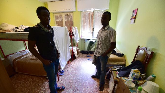 Men stand in a room at a center for migrants on May 14, 2015 in Aoste, the first region in Italy to refuse to welcome more migrants