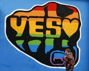 Men walk past a Yes vote campaign graffiti in central …
