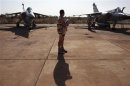 A French soldier stands between two Mirage F1 fighter jets at the Malian army air base in Bamako
