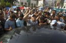 Supporters of Mursi gather around a car carrying the body of a fellow supporter killed by violence in Cairo