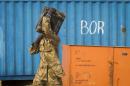 A South Sudanese government soldier carries an ammunition box from storage at the airport in Bor, Jonglei State, South Sudan Sunday, Jan. 19, 2014. Leaders for warring sides in South Sudan's monthlong internal conflict say they are close to signing a cease-fire and the South Sudanese military spokesman said that army forces had retaken the key city of Bor Saturday, defeating 15,000 rebels. (AP Photo/Mackenzie Knowles-Coursin)