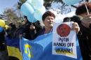 Participants hold placards and shout slogans during an anti-war rally in the Crimean town of Bakhchisaray