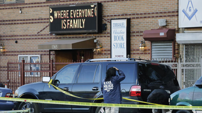 New York Police Department crime scene investigators photograph evidence outside Emmanuel Church of God, Tuesday, April 28, 2015, in the Brooklyn borough of New York. Two men were killed Monday night during a shooting outside the Flatbush neighborhood church where a funeral was taking place. Four other people were injured and are in stable condition. (AP Photo/Mark Lennihan)