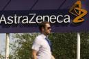 A man walks past a sign at an AstraZeneca site in Macclesfield