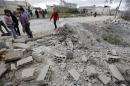 Residents inspect damaged ground after a shell fell in the rebel held town of Jarjanaz, southern Idlib countryside