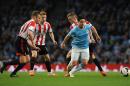 Manchester City's Samir Nasri, right, evades Sunderland's Andrea Dossena, left, Jack Colback and Sebastian Larsson during the English Premier League soccer match between Manchester City and Sunderland at The Etihad Stadium, Manchester, England, Wednesday, April 16, 2014. (AP Photo/Rui Vieira)