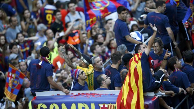 Barcelona&#39;s Xavi waves to supporters as he cleberates with team mates and staff members from an open-top bus during celebration parade in Barcelona