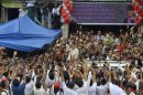 Myanmar pro-democracy leader Suu Kyi waves to supporters as she leaves National League for Democracy party headquarters after attending her 68th birthday ceremony in Yangon