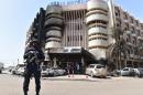A policeman stands guard in front of the Splendid hotel, on January 17, 2016 in Ouagadougou, following a jihadist attack by Al-Qaeda linked gunmen