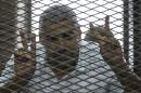 Al-Jazeera news channel's Egyptian-Canadian Mohamed Fadel Fahmy listens to the verdict inside the defendants cage during his trial for allegedly supporting the Muslim Brotherhood on June 23, 2014 at the police institute in Cairo