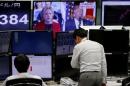 Employees of a foreign exchange trading company work near monitors displaying U.S. Democratic presidential nominee Clinton and U.S. Republican presidential nominee Trump on TV news, in Tokyo