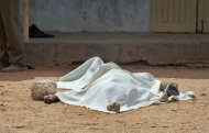 A body of one of those killed in the attack lies covered by a sheet, outside the African Inland Church in Garissa, Kenya Sunday, July 1, 2012. Gunmen killed two policemen guarding a church, snatched their rifles and then opened fire on the congregation with bullets and grenades on Sunday, killing at least 10 people and wounding at least 40, security officials said, with militants from Somalia being immediately suspected. (AP Photo/Chris Mann)