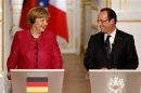 France's President Hollande and German Chancellor Angela Merkel attend a joint news conference at the Elysee Palace in Paris