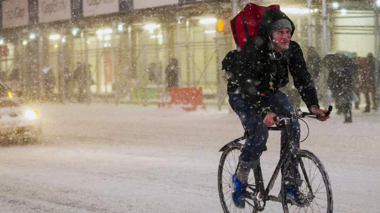 A man rides his bike in the snow storm through Times Square in Manhattan in New York