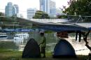 An anti-government protester adjusts her tent in Lumpini Park in downtown Bangkok