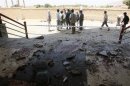 Afghan officials stand at the site of attack in Samangan province