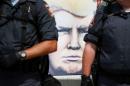 A painting of Donald Trump is seen as police officers stand guard outside Public Square at the Republican National Convention in Cleveland, Ohio