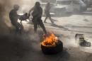 Egyptian riot policemen douse burning tyres during a rally to mark the first anniversary of the military ouster of president Mohamed Morsi on July 3, 2014 in Cairo