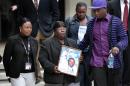 Edna Glover, second left, mother of Henry Glover, leaves Federal Court holding his photo, after the sentencing of two former New Orleans police oficers in his shooting death and burning of his body in New Orleans, Thursday, March 31, 2011. Former officer David Warren was sentenced to more than 25 years for shooting Glover without justification after Hurricane Katrina, and his ex-colleague Gregory McRae was given just over 17 years for burning the body. Right is Corey Glover, cousin of Henry, and background right is Patrice Glover, sister of Henry. (AP Photo/Gerald Herbert)